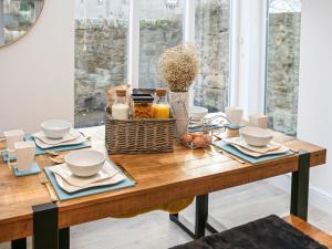 a dining room table with a table cloth and dishes on it at Forget Me Not Cottage in Culross