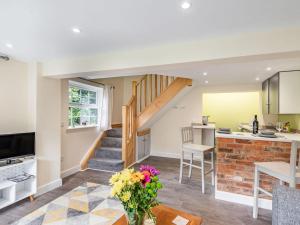 eine Küche und ein Wohnzimmer mit einer Treppe in einem Haus in der Unterkunft Owl Cottage in Howell