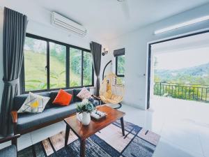 ROSE Villas & Resort - Ba Vi في هانوي: غرفة معيشة مع أريكة وطاولة