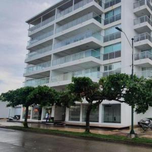 un edificio alto y blanco con árboles delante en Apartamento Edificio Sea View, en San Andrés