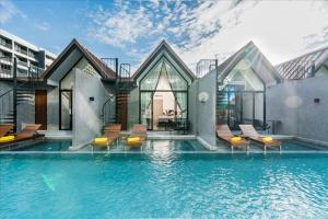 ナ・ジョムティエンにあるAna Anan Resort & Villas Pattayaの建物前のスイミングプール付き住宅