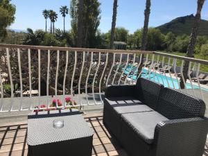 un patio con sofá, mesa y piscina en Hôtel Restaurant Les Chasseurs en Marine de Pietracorbara