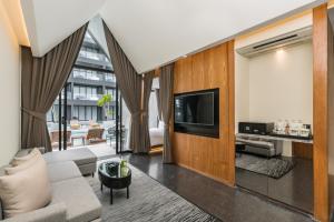 a living room with a couch and a tv at Ana Anan Resort & Villas Pattaya in Na Jomtien