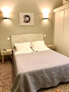 een slaapkamer met een groot bed met 2 kussens bij Hôtel Restaurant Les Chasseurs in Marine de Pietracorbara