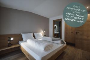 a bedroom with a large bed with white sheets at Apartments Koflhaus in Cadipietra