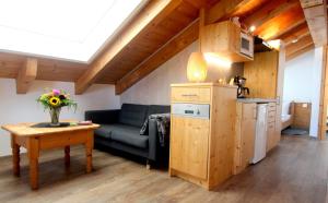 ein Wohnzimmer mit einem Sofa und einem Tisch in der Unterkunft Appartementhaus Schirsner in Schliersee