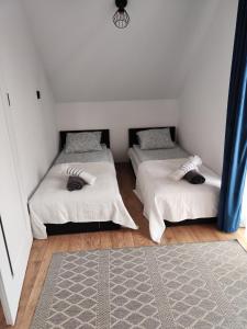 two twin beds in a room with a rug at Leśny Zaułek in Muszyna +36 photos