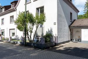 a white building with a tree in front of it at Modern Apartment in Lüdenscheid in Lüdenscheid