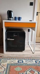 a desk with a microwave sitting under a table at Fairlight Cove in Fairlight