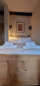 a large bed with white sheets and pillows on it at Fairlight Cove in Fairlight