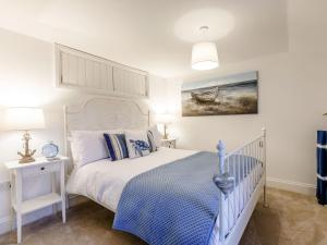 a bedroom with a bed with a blue and white bedspread at Lake View-uk34414 in Cheddar