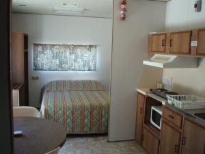 um pequeno quarto com uma cama e uma cozinha em Lakeside Tourist Park em Robe
