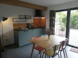 a kitchen with a wooden table and a table and chairs at Noest in Destelbergen