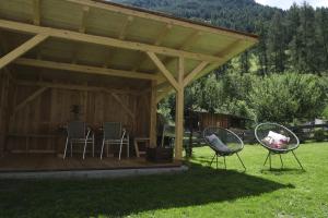 a gazebo with two chairs in a yard at Apartments Koflhaus in Cadipietra