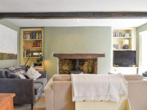 sala de estar con sofá y chimenea en St James Cottage, en Shaftesbury