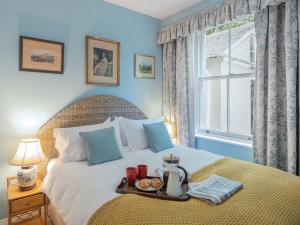 a bedroom with a bed with a tray of food on it at The Nook At Henge Estate in Shrewton