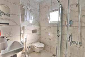 特拉布宗的住宿－Azra Suite Otel，带淋浴、卫生间和盥洗盆的浴室
