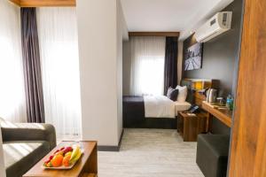 Habitación de hotel con cama y mesa con fruta. en Azra Suite Otel en Trebisonda