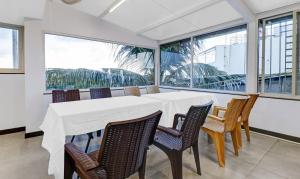 - une salle à manger avec une table, des chaises et des fenêtres dans l'établissement Treebo Trend Elite Heritage, à Bangalore