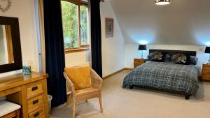 a bedroom with a bed and a desk and a chair at Carn A Chuilinn in Fort Augustus