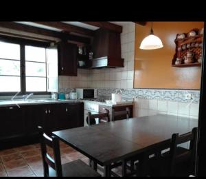kuchnia z drewnianym stołem i krzesłami oraz stołem i stołem w obiekcie La Rectoral de Valdedios.Casa rural con chimenea w mieście La Piñera