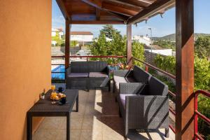 een patio met stoelen en tafels op een balkon bij Villa Salvia Mare in Bilice