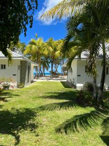 vistas al patio de una casa con palmeras en Cap Jean Marie Beach Villas en Anse Kerlan