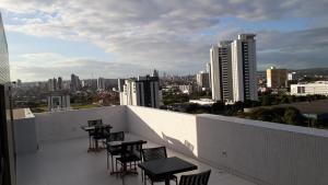 einen Balkon mit Tischen und Stühlen und einer Skyline der Stadt in der Unterkunft Maravilhoso Apt 104 Home Service próximo Shopping Partage e Rodoviária in Campina Grande