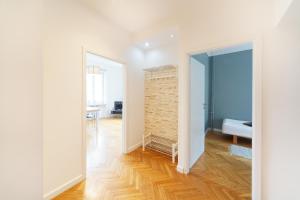 een kamer met witte muren en een houten vloer bij Old Town Kanonia Apartments in Warschau