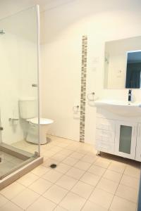 a bathroom with a toilet and a sink and a shower at Centrepoint Apartments Griffith in Griffith