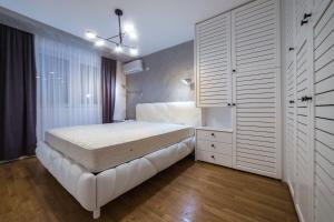 a bedroom with a white bed and a large closet at Apartman Pesic in Pirot