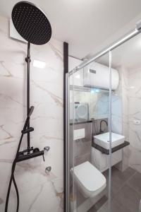 a bathroom with a glass shower stall with a toilet at Apartman Pesic in Pirot