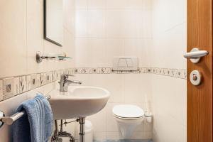 a white bathroom with a sink and a toilet at Residence Diana Apartment 303 in Terento +15 photos