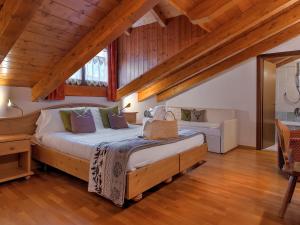 um quarto com uma cama grande num sótão em Hotel Caminetto em Folgarida
