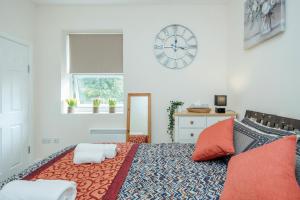 a bedroom with a bed with a clock on the wall at Modern Elegant Luxury 1 bed flat Free parking 