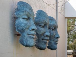 a wall with three face heads on it at Seven Villa Hotel & Spa in Johannesburg