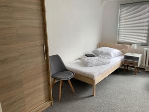 a bedroom with a bed and a chair next to a door at Wohnung 85 qm Kalimandscharo 1 in Zielitz - Magdeburg in Zielitz