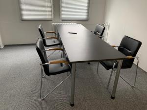 een vergaderzaal met een tafel en vier stoelen bij Wohnung 85 qm Kalimandscharo 1 in Zielitz - Magdeburg in Zielitz