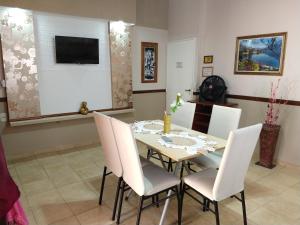 a dining room with a table and white chairs at Departamentos San Pedro in San Pedro +18 photos