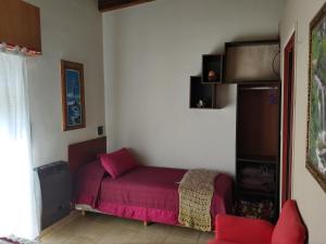 a bedroom with a bed with red sheets and a chair at Departamentos San Pedro in San Pedro