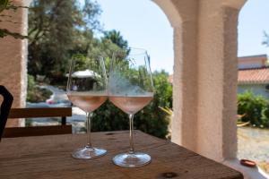 - deux verres de vin assis sur une table en bois dans l'établissement Lilly - Lovely small Villa among Olive Trees, à Sarroch
