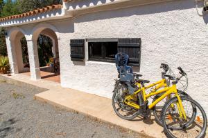 un vélo jaune garé devant une maison dans l'établissement Lilly - Lovely small Villa among Olive Trees, à Sarroch