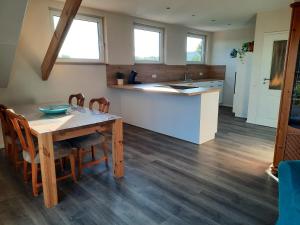 eine Küche und ein Esszimmer mit einem Holztisch in der Unterkunft Valentinushof in Beckingen