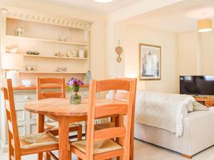 a kitchen and living room with a table and chairs at Hall Piece Cottage in Olney