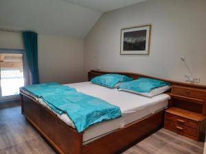 ein Schlafzimmer mit einem Bett mit blauen Kissen darauf in der Unterkunft Valentinushof in Beckingen