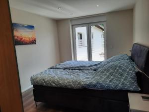 1 dormitorio con cama y ventana en Valentinushof, en Beckingen