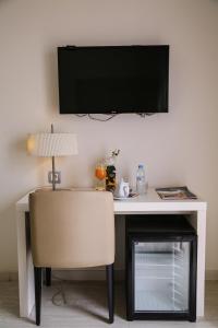 a desk with a chair and a television on a wall at Al Mandari Hôtel Tétouan in Tétouan