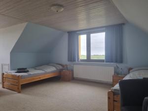 本特維施的住宿－Pension Küstenkind，一间卧室设有两张床和窗户。