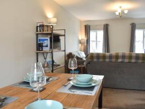 a living room with a table with glasses and a couch at 6 Twentyman Court in Keswick