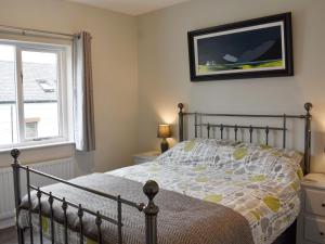 a bedroom with a bed and a window at 6 Twentyman Court in Keswick